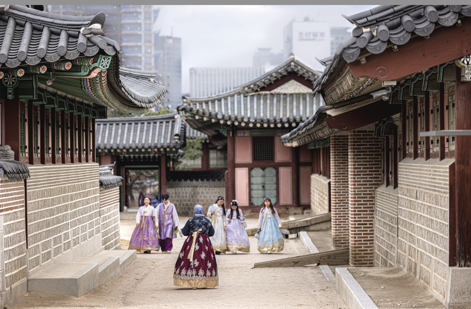 Figures in hanbok walking a palace lane, Korea