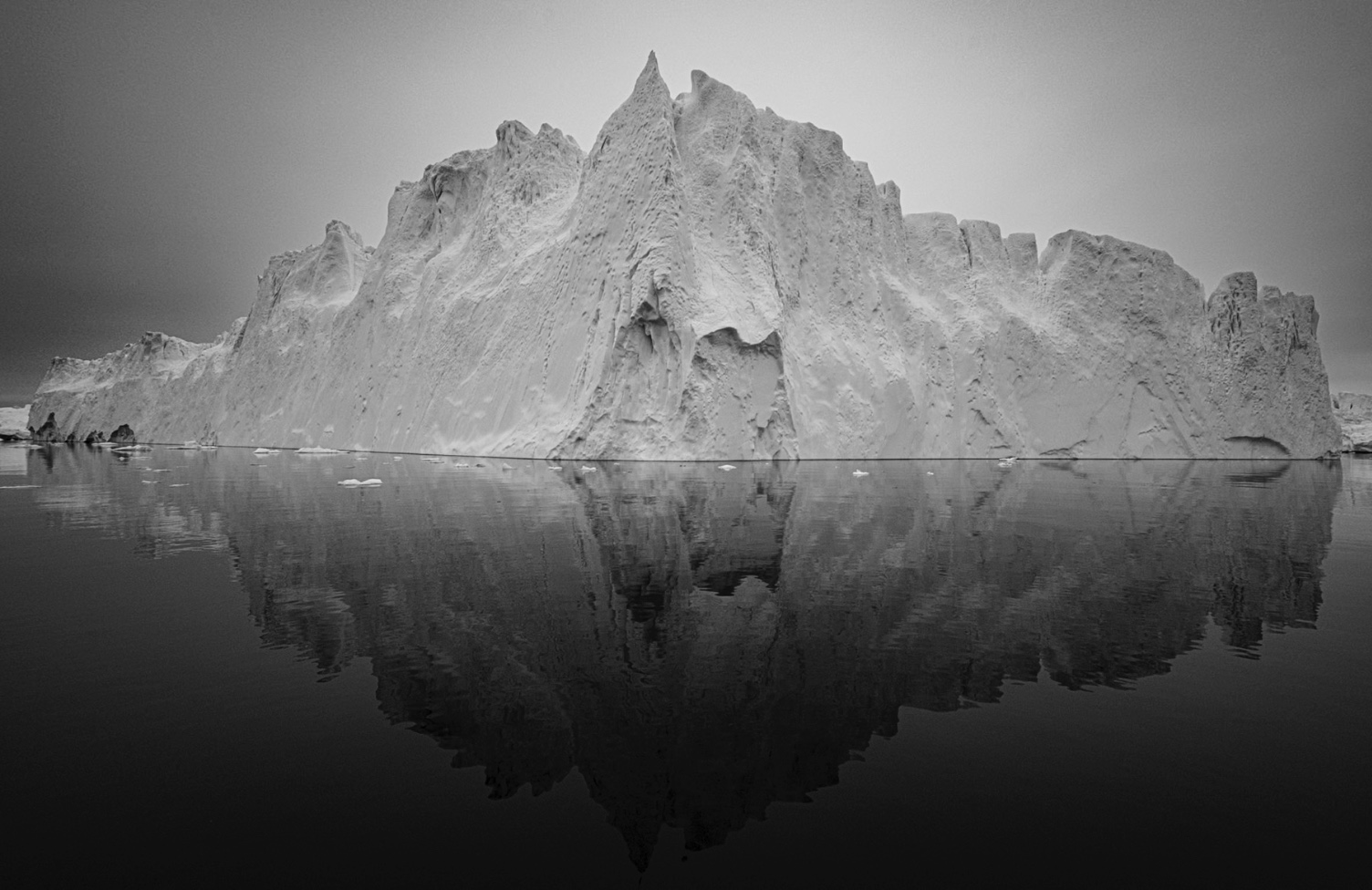 An iceberg and its mirror reflection in black and white
