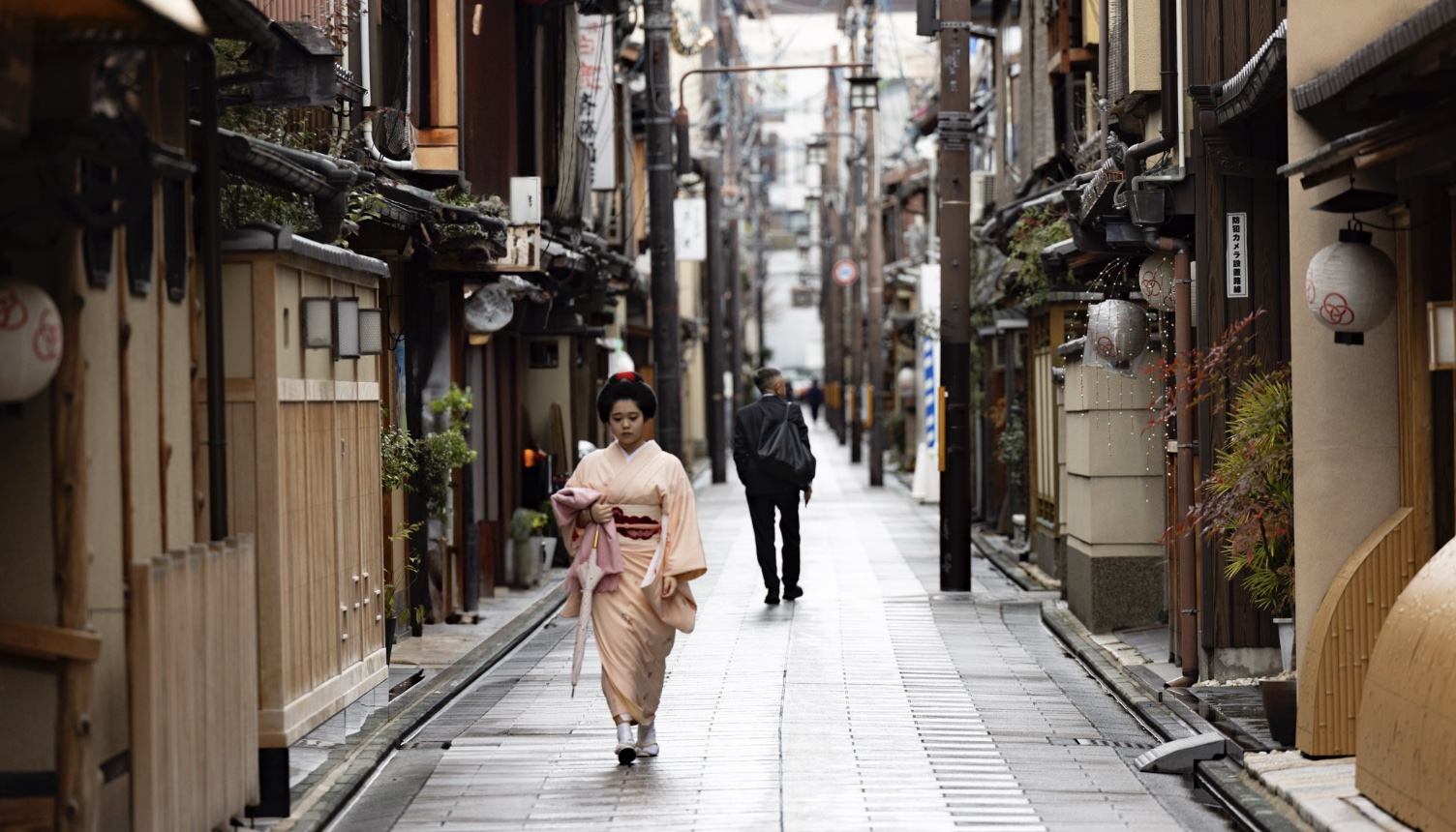 A figure in kimono in a Kyoto alley